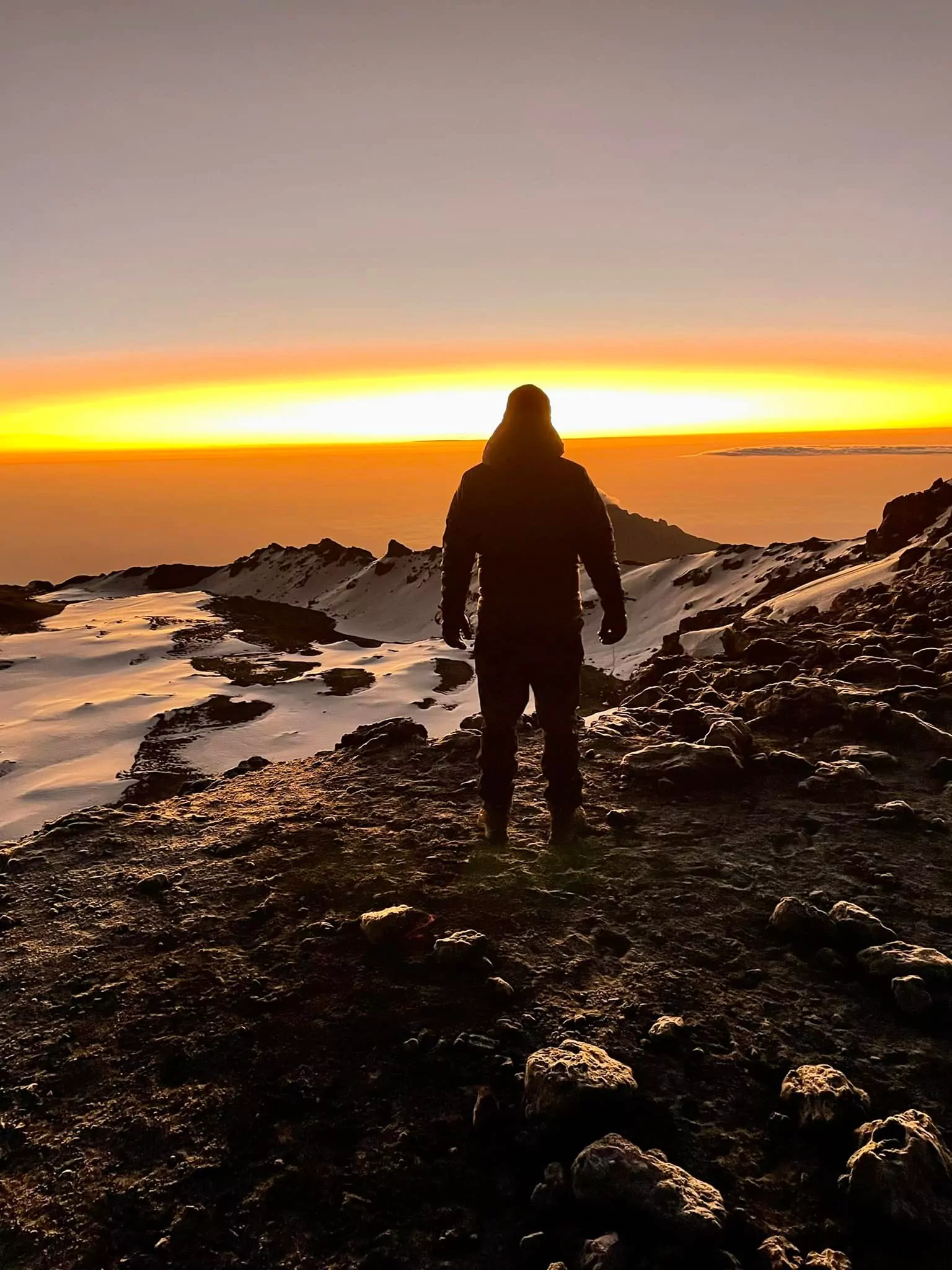 Trekker im Sonnenaufgang in der kalten Gipfelzone des Kilimanjaro