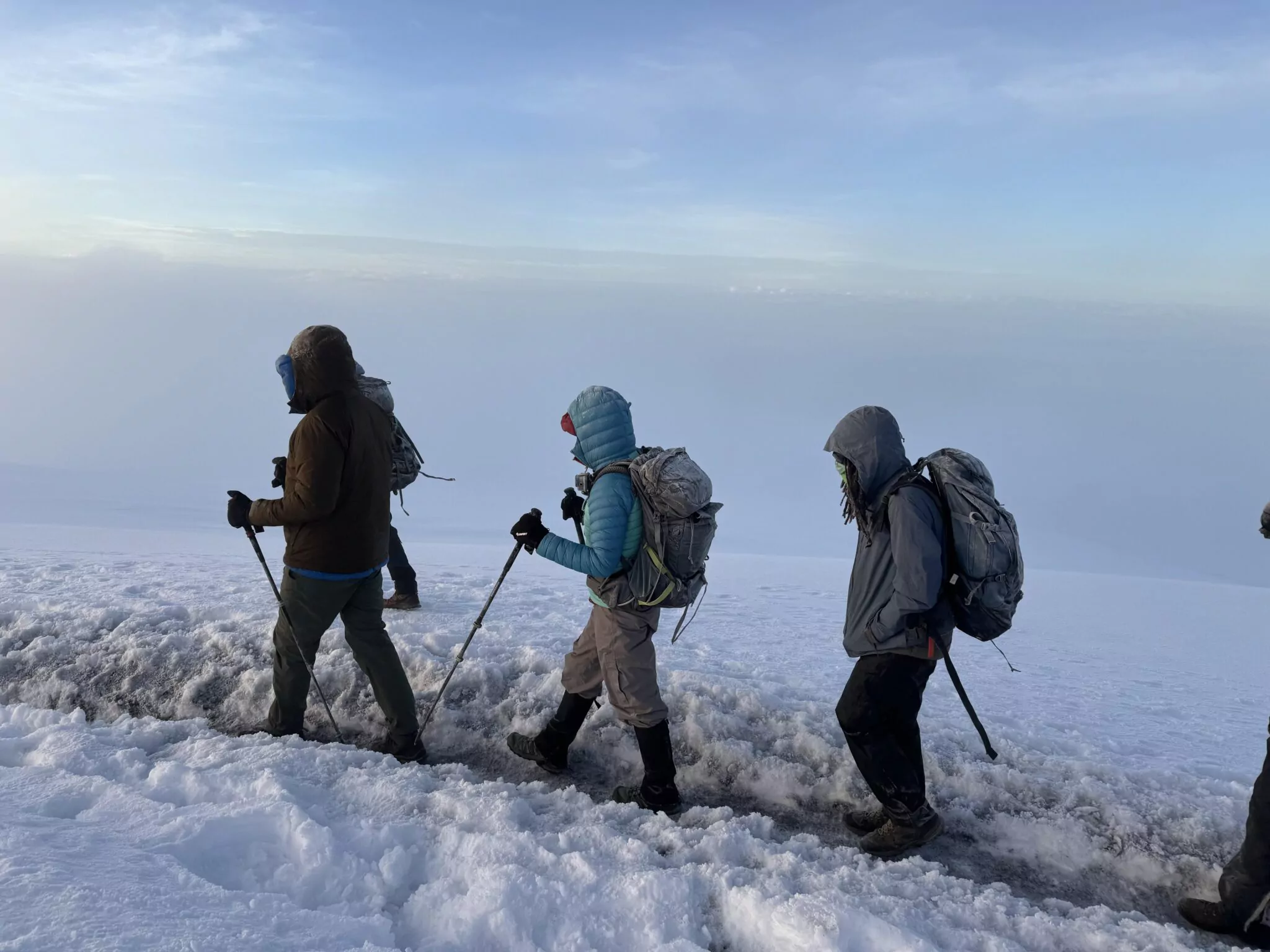 Bergsteiger auf einem verschneiten Pfad in großer Höhe am Kilimandscharo