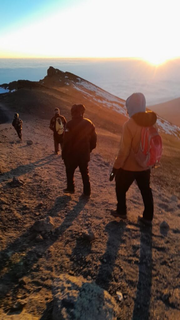 Trekker bei Sonnenaufgang auf dem Weg zum Gipfel über die Marangu-Route