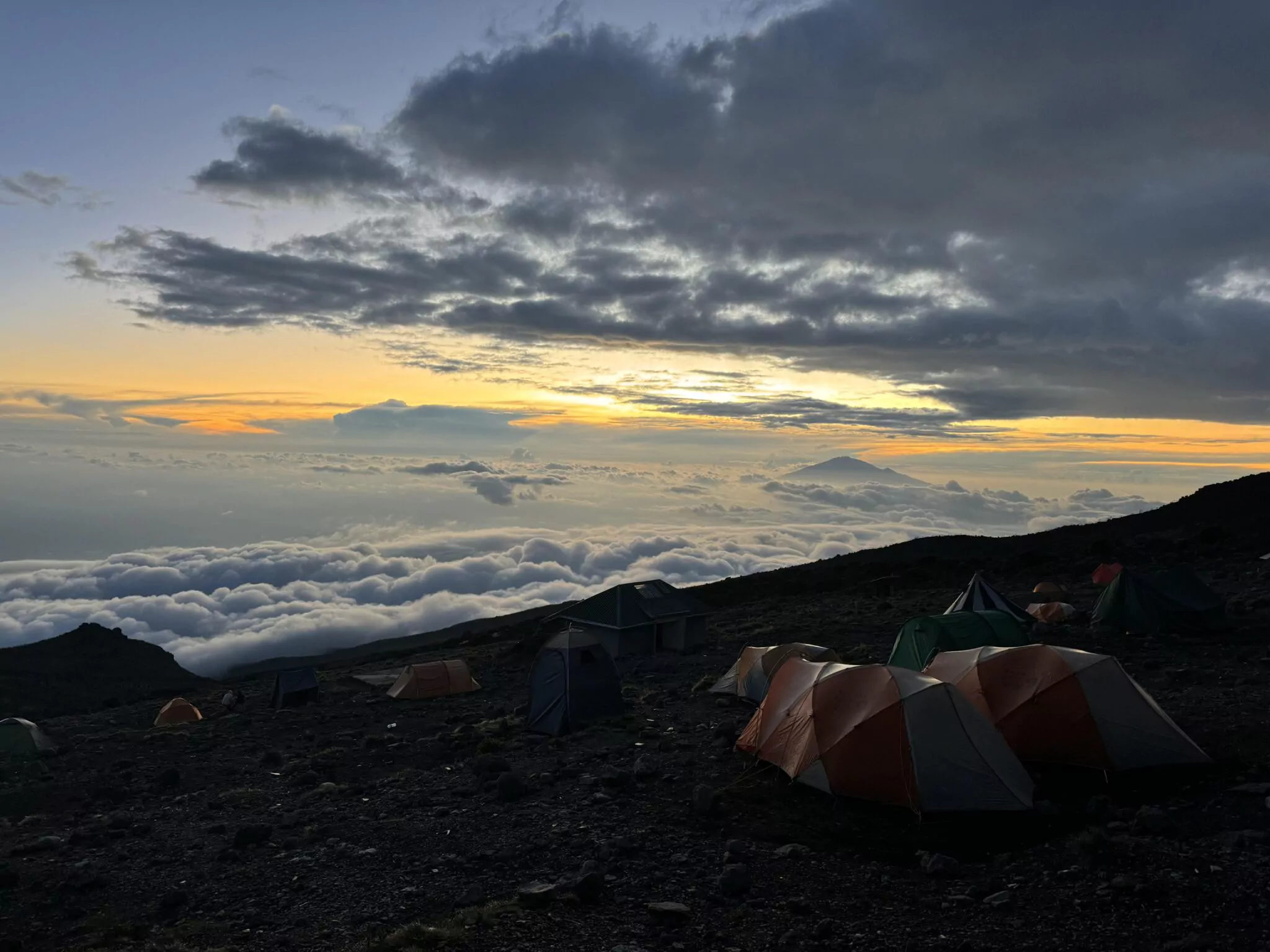 Zeltcamp am Kilimanjaro bei Sonnenaufgang über den Wolken