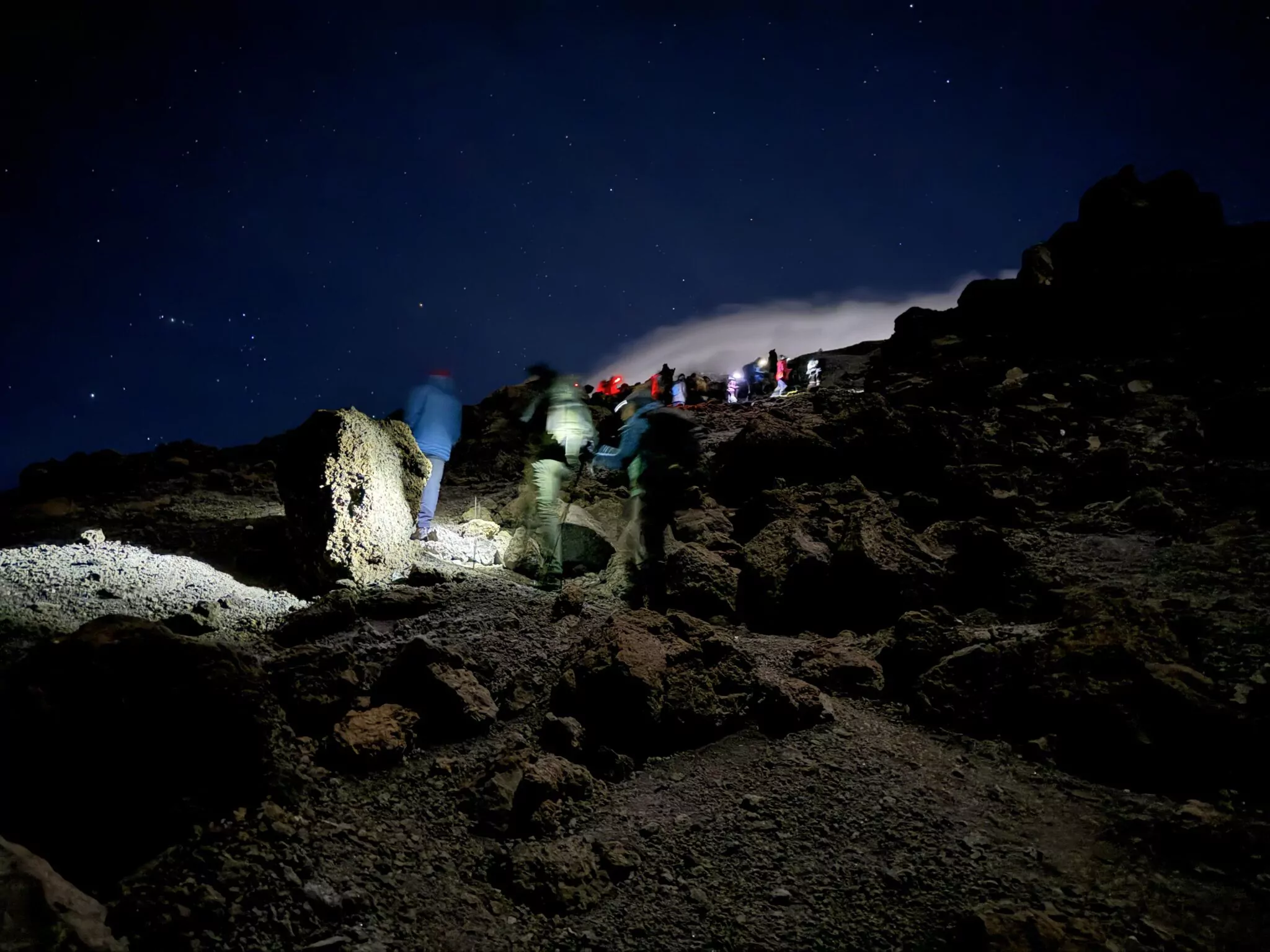Trekker mit Stirnlampen in der Gipfelnacht am Kilimanjaro