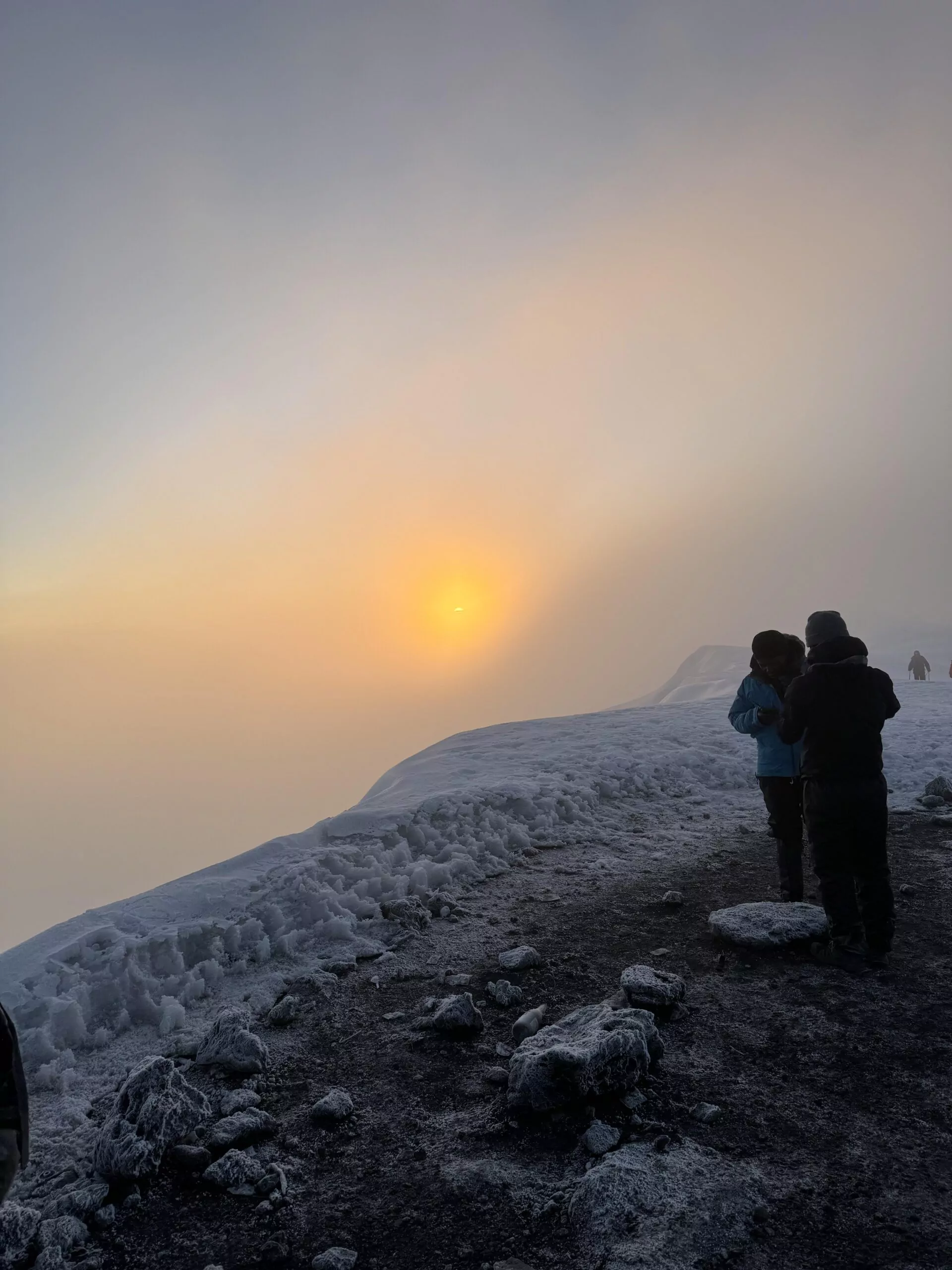 Bergsteiger bei Sonnenaufgang in großer Höhe am Kilimanjaro